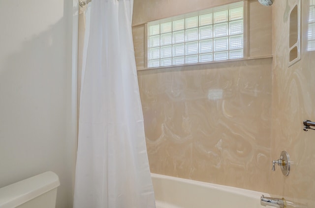 bathroom featuring shower / bath combination with curtain and toilet