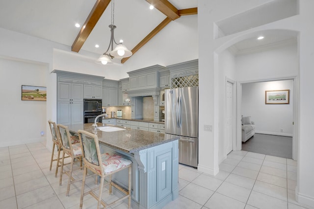 kitchen featuring gray cabinetry, sink, a kitchen bar, a kitchen island with sink, and black appliances