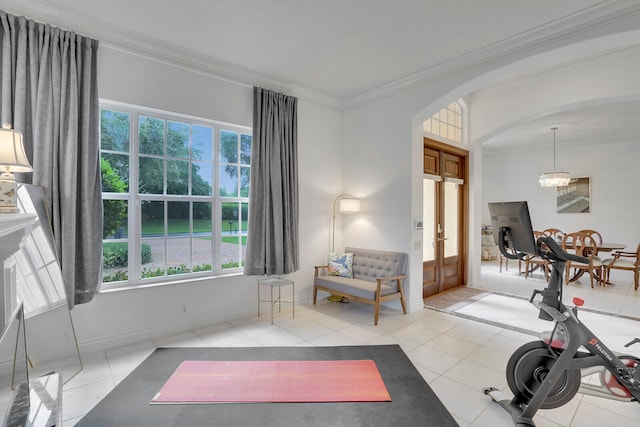 workout room featuring plenty of natural light, light tile patterned flooring, and crown molding