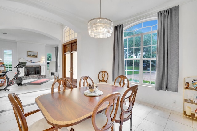 dining room with light tile patterned floors, an inviting chandelier, and crown molding