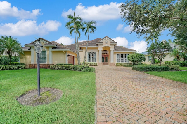 ranch-style home featuring a front lawn and a garage