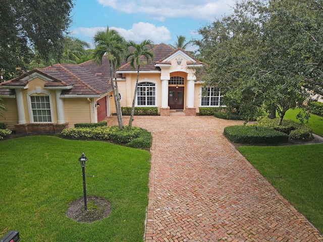 view of front of property with a garage and a front lawn