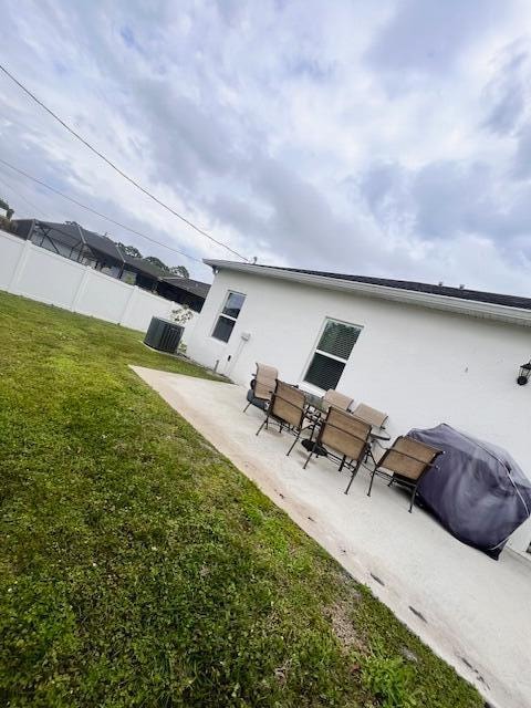 back of house featuring a lawn and a patio area