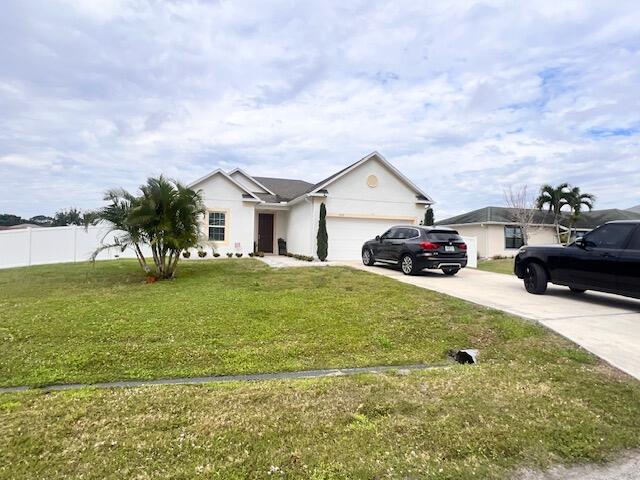 ranch-style house with a garage and a front yard