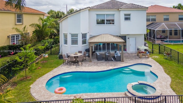 back of house with a lawn, a swimming pool with hot tub, and a patio