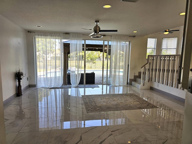 empty room with marble finish floor, recessed lighting, visible vents, a textured ceiling, and baseboards