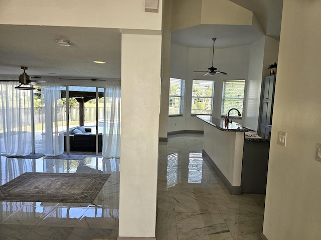 hall featuring marble finish floor, plenty of natural light, visible vents, and a sink