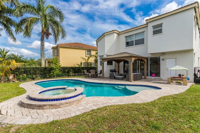 view of pool with a pool with connected hot tub, a patio, a gazebo, and fence