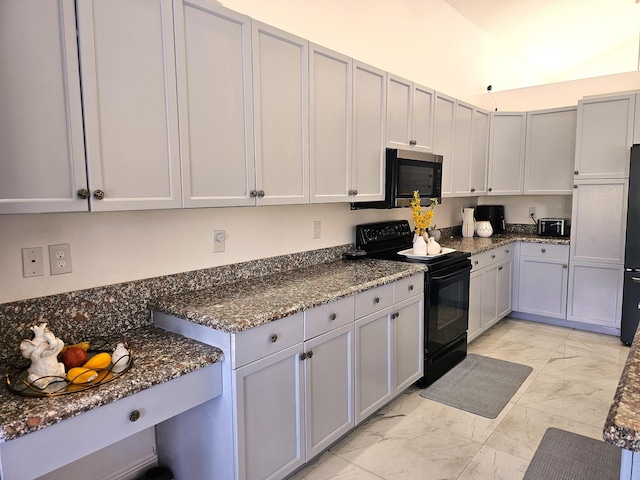 kitchen with dark stone counters, marble finish floor, built in fridge, and black electric range oven