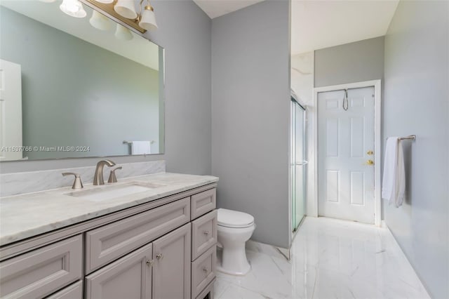 full bath featuring marble finish floor, vanity, a shower stall, and toilet