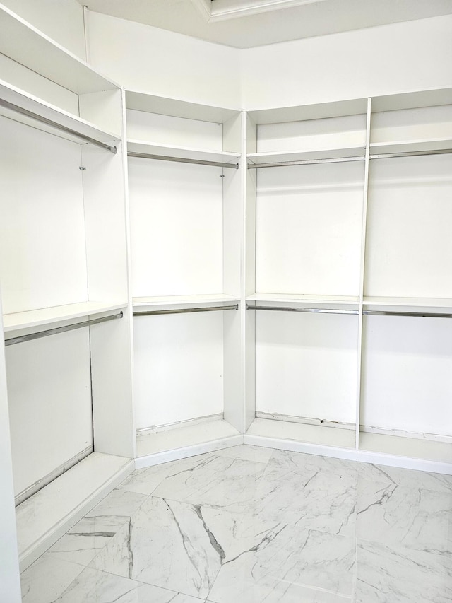 walk in closet with marble finish floor