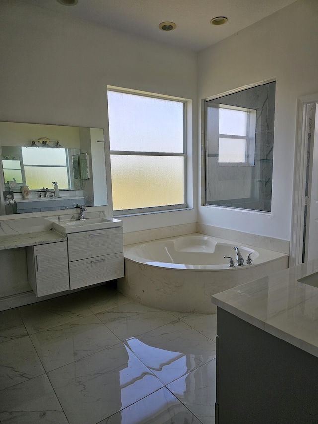 full bathroom with marble finish floor, vanity, and a bath