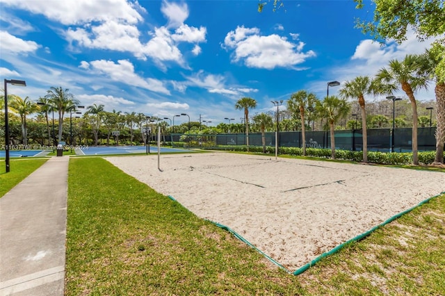 view of home's community featuring volleyball court, a yard, and fence