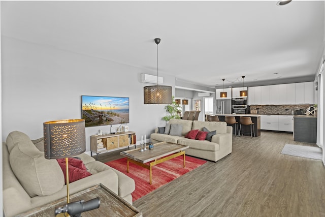 living room with wood-type flooring and a wall mounted air conditioner