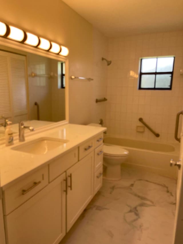 full bathroom featuring vanity, tiled shower / bath combo, and toilet