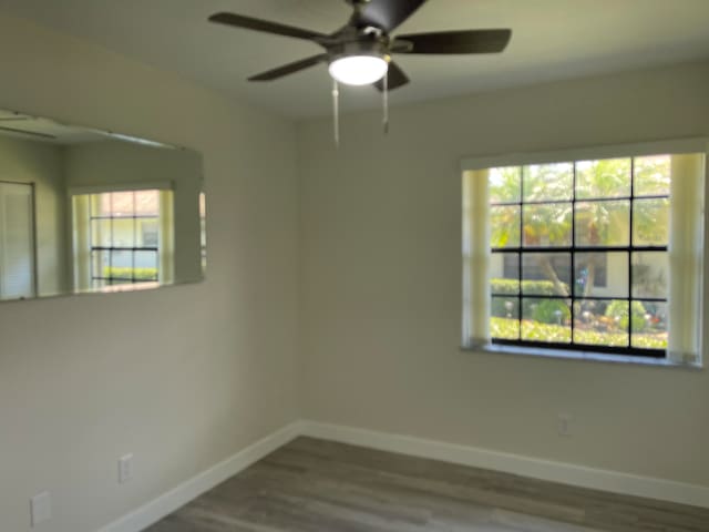 unfurnished room featuring ceiling fan, plenty of natural light, and hardwood / wood-style flooring