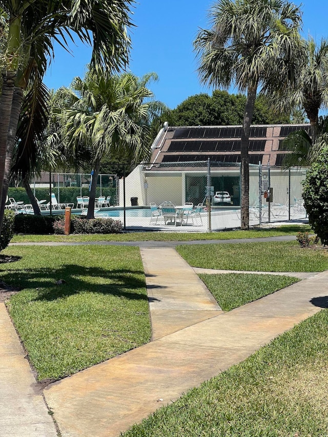 view of community featuring a yard, a patio, and a swimming pool