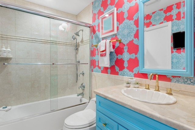 full bathroom featuring vanity, combined bath / shower with glass door, and toilet