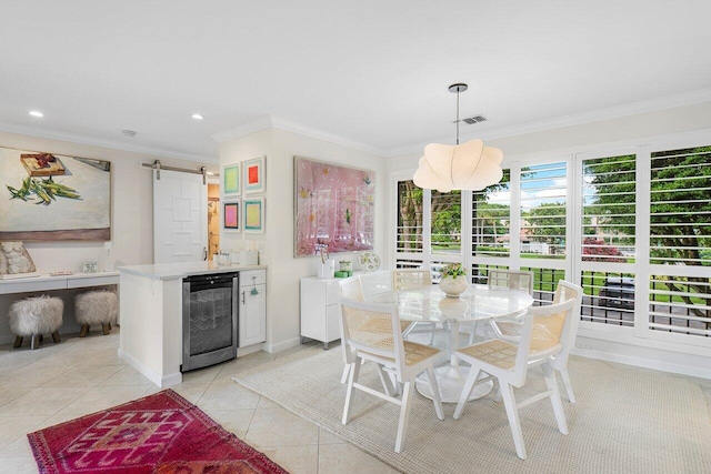 dining room featuring a barn door, crown molding, light tile patterned floors, and wine cooler