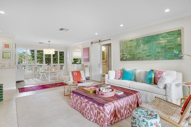 tiled living room with crown molding and a barn door