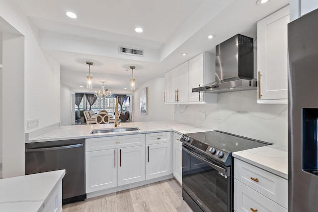 kitchen with black range with electric stovetop, white cabinetry, dishwasher, wall chimney range hood, and light hardwood / wood-style floors