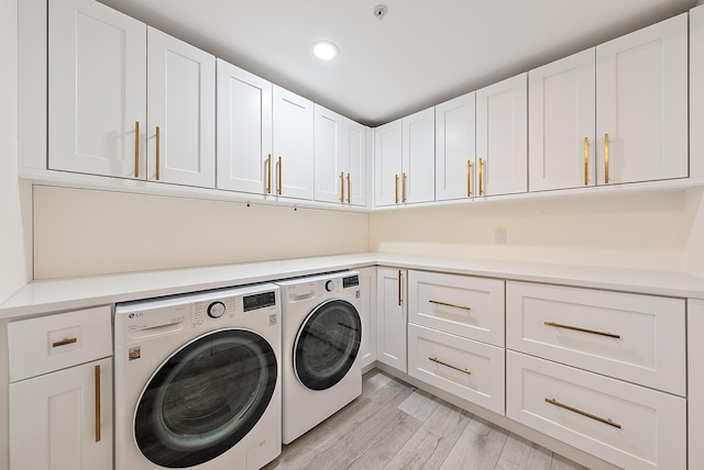 laundry room with cabinets, separate washer and dryer, and light hardwood / wood-style floors