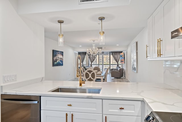 kitchen with sink, white cabinets, hanging light fixtures, and appliances with stainless steel finishes