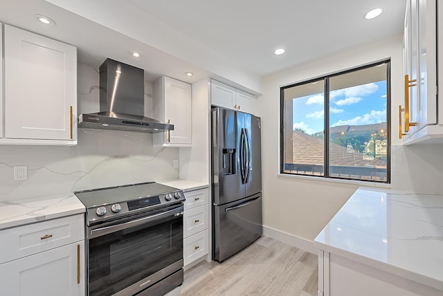 kitchen featuring range, white cabinets, wall chimney range hood, and stainless steel refrigerator with ice dispenser