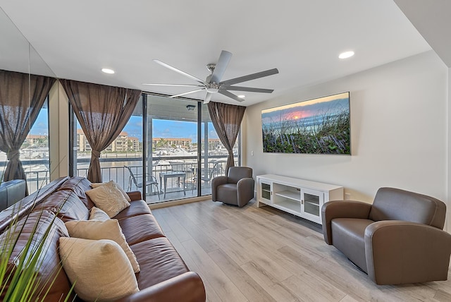 living room featuring ceiling fan and light hardwood / wood-style floors