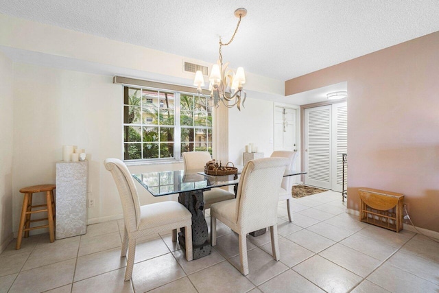 tiled dining area featuring a textured ceiling and a notable chandelier