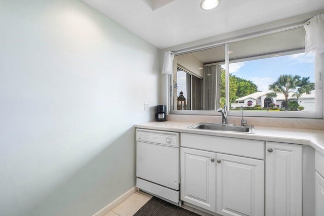 kitchen with dishwasher, light tile patterned flooring, white cabinetry, and sink