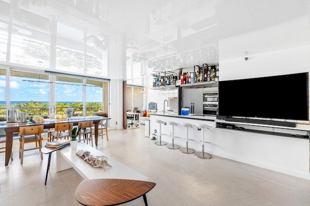 interior space with a healthy amount of sunlight, light tile patterned flooring, sink, and stainless steel appliances