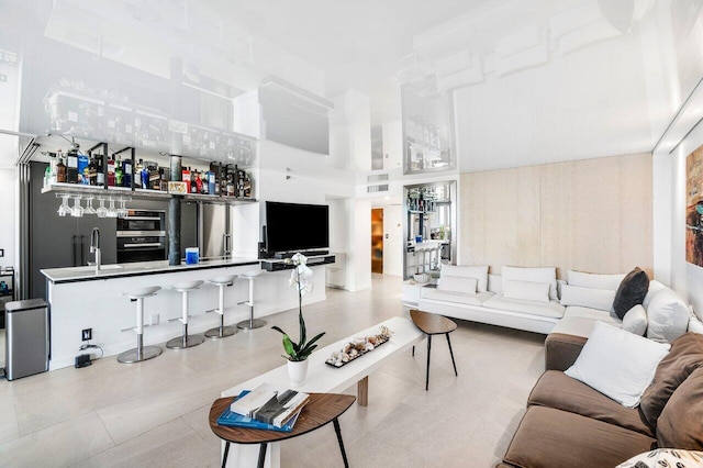 living room with a high ceiling and indoor wet bar