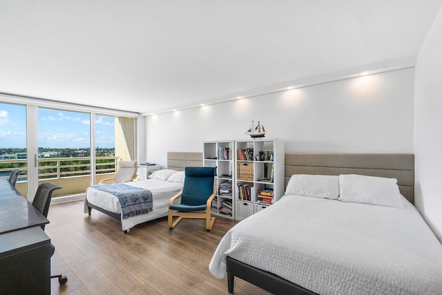 bedroom with floor to ceiling windows and wood-type flooring