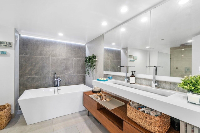 bathroom with vanity, tile patterned floors, tile walls, and independent shower and bath