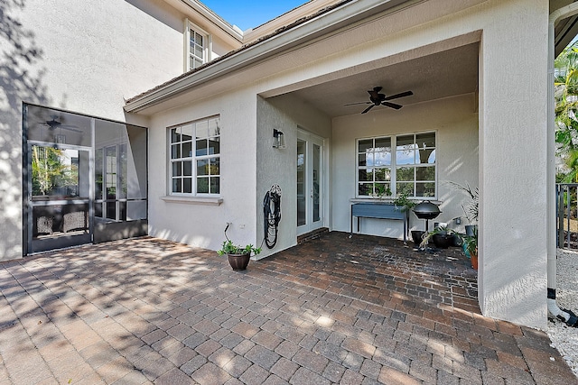 view of exterior entry with a patio and ceiling fan