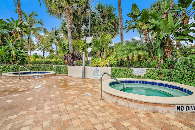 view of pool with a hot tub