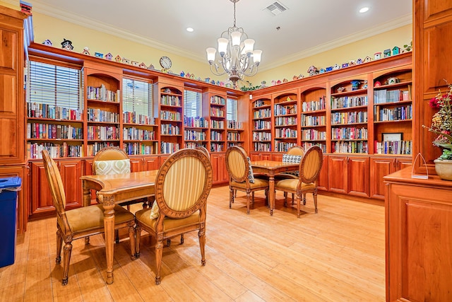 dining space with crown molding, an inviting chandelier, and light hardwood / wood-style flooring