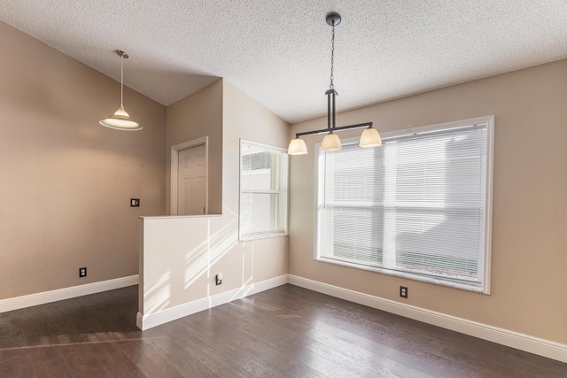 unfurnished dining area with a textured ceiling, dark hardwood / wood-style floors, and lofted ceiling