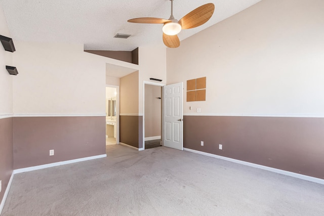 carpeted empty room with a textured ceiling, high vaulted ceiling, and ceiling fan