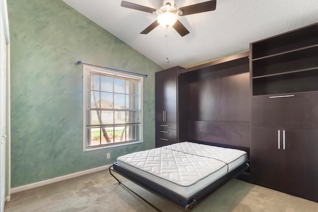 bedroom featuring ceiling fan, light colored carpet, lofted ceiling, and a textured ceiling