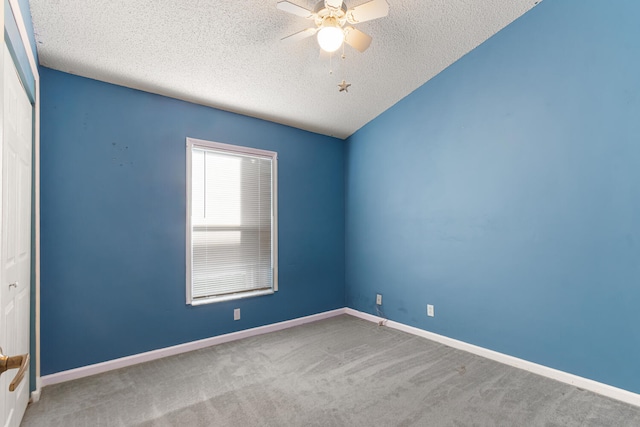 carpeted spare room with lofted ceiling, ceiling fan, and a textured ceiling