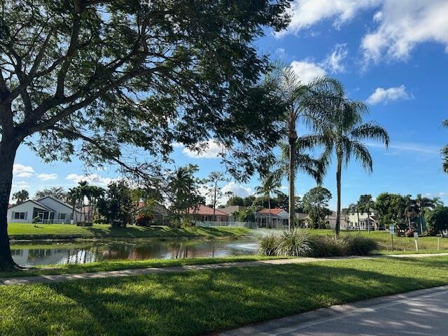 view of community with a lawn and a water view