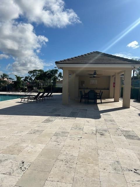 view of patio featuring ceiling fan and a community pool