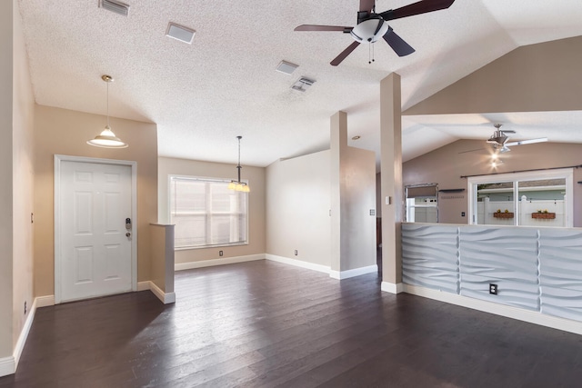 unfurnished living room featuring ceiling fan, dark hardwood / wood-style flooring, lofted ceiling, and a textured ceiling