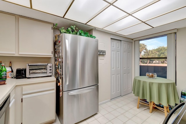 kitchen with white cabinets, light tile patterned floors, and stainless steel appliances