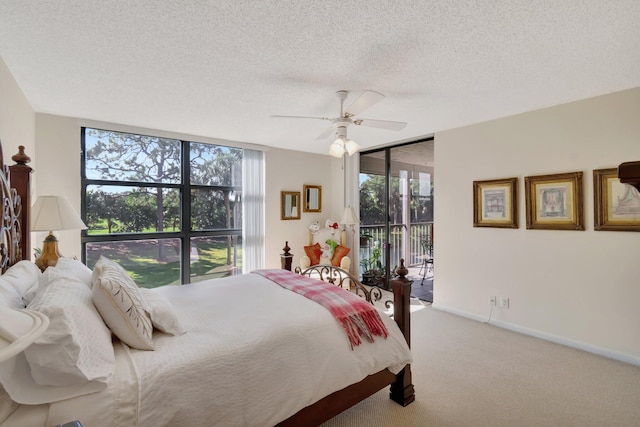 bedroom with multiple windows, a textured ceiling, access to exterior, and ceiling fan