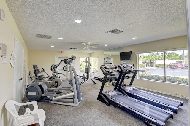 gym featuring ceiling fan, carpet, and a textured ceiling