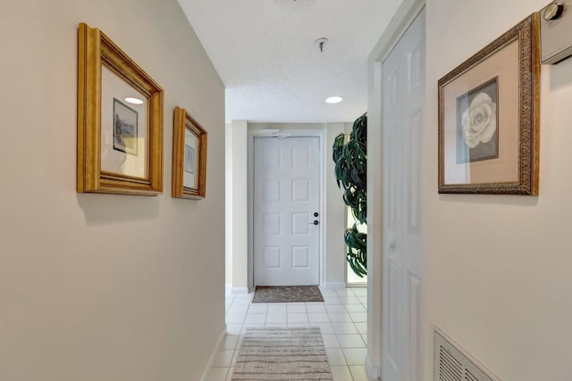 doorway with light tile patterned flooring and a textured ceiling