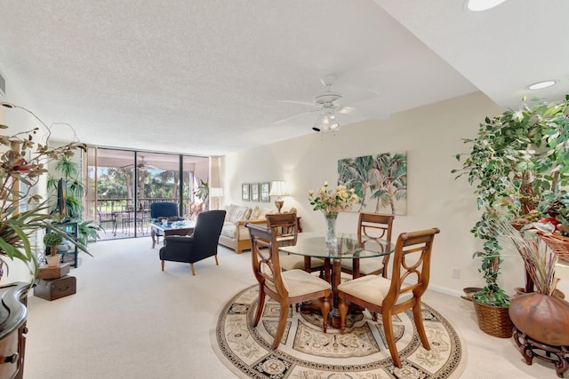 dining area featuring light carpet, a textured ceiling, and ceiling fan